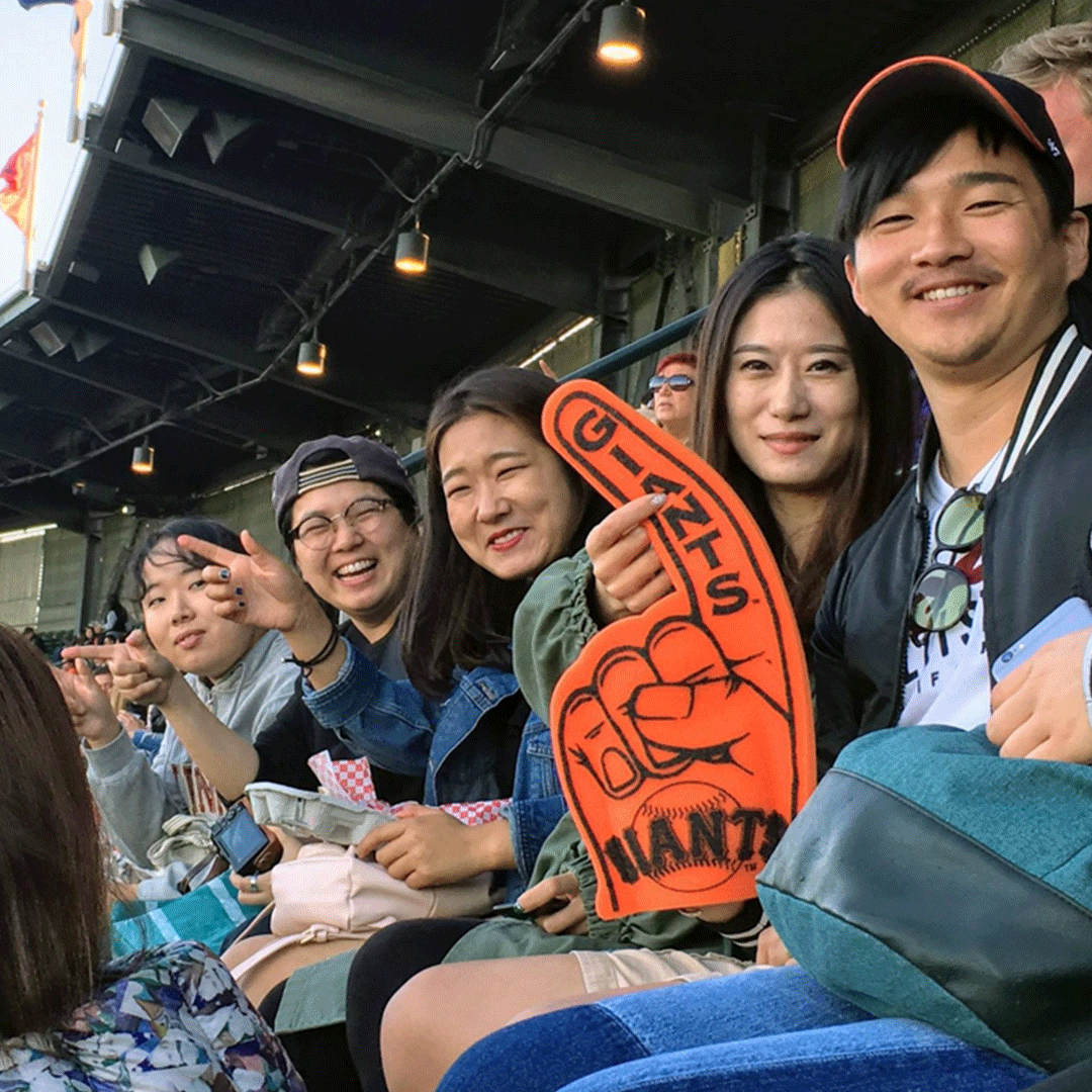 American Language Institute students at a Giants game holding a big #1 foam hand