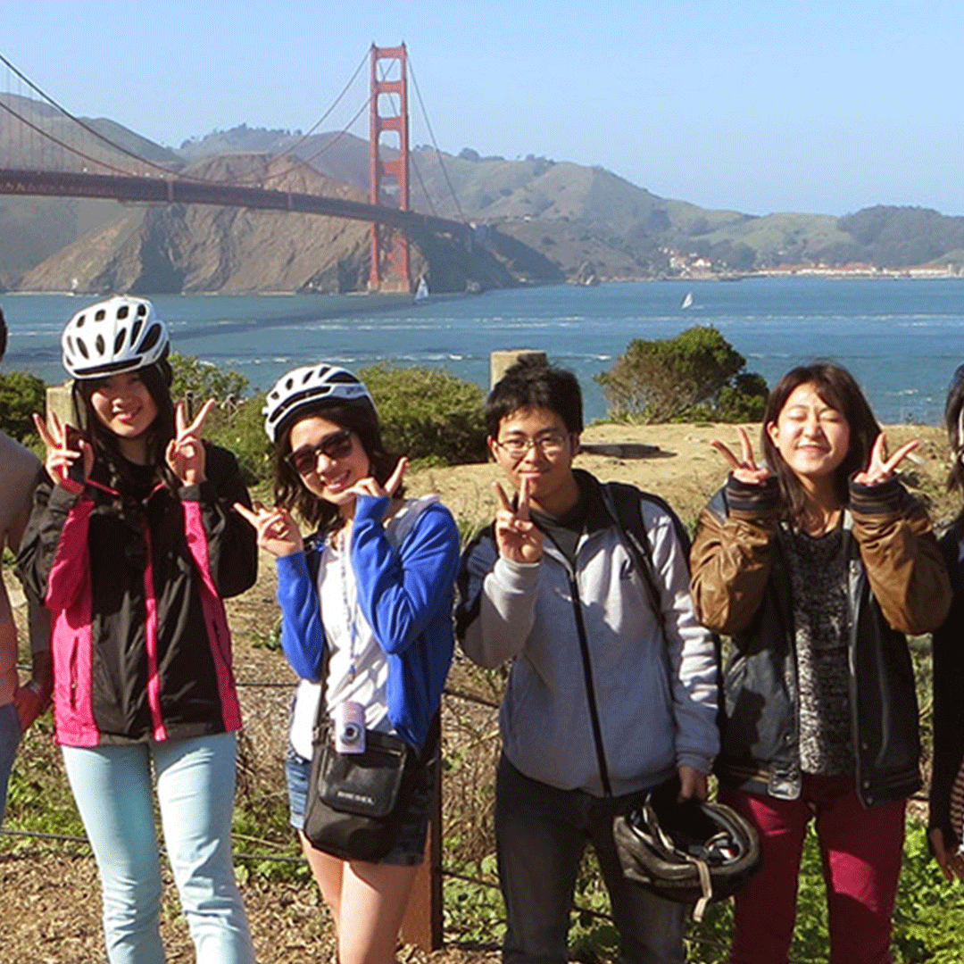 International students flash peace signs int front of Golden Gate Bridge
