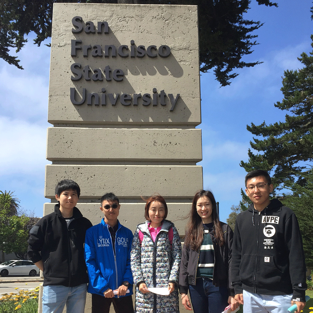International students pose by the SF State sign