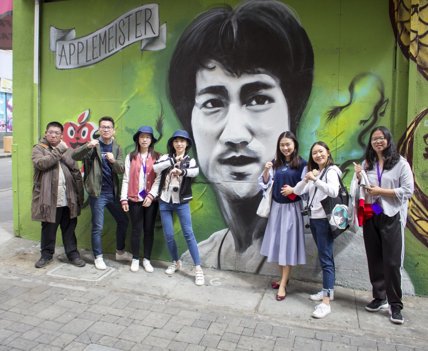 International students pose in front on Bruce Lee mural