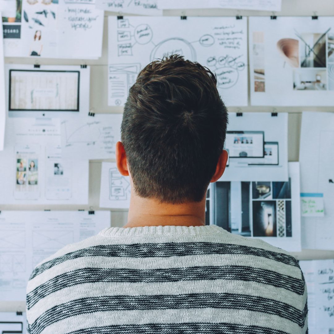 Designer looks at his UX materials on the wall