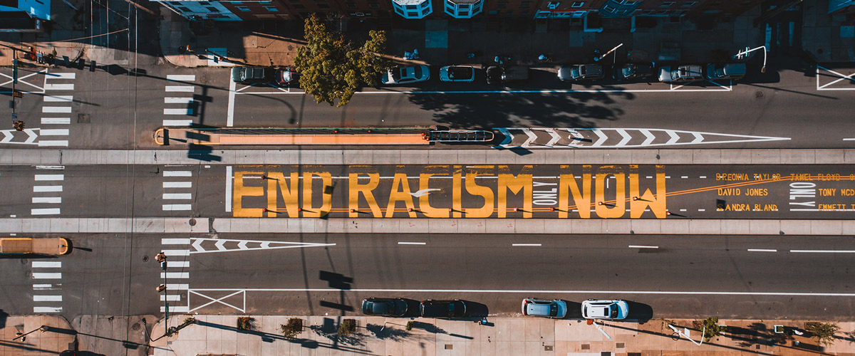 Aerial photo of street with painted words "End Racism Now"