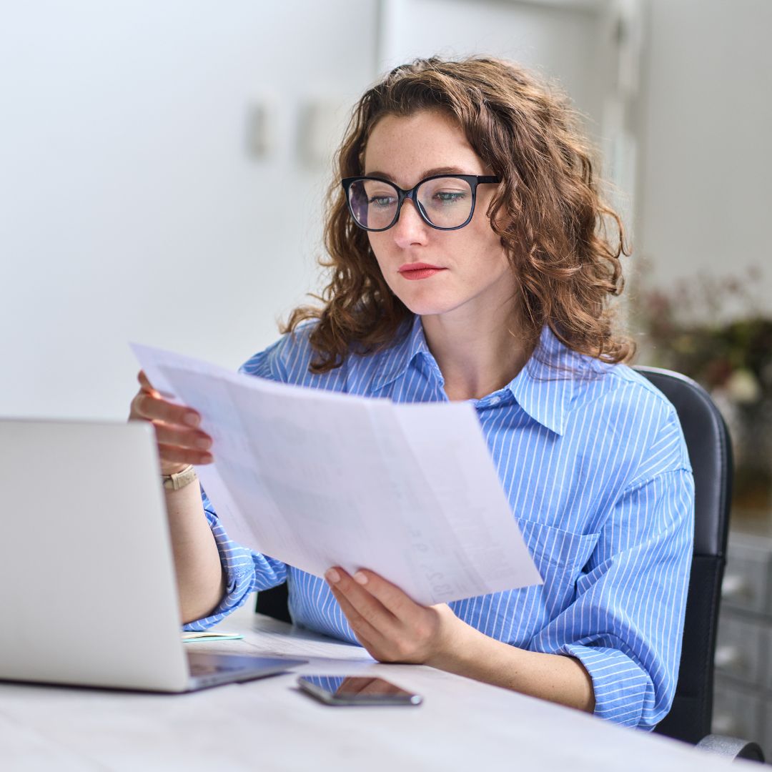 Medical Billing and Coding Professional working with papers and laptop