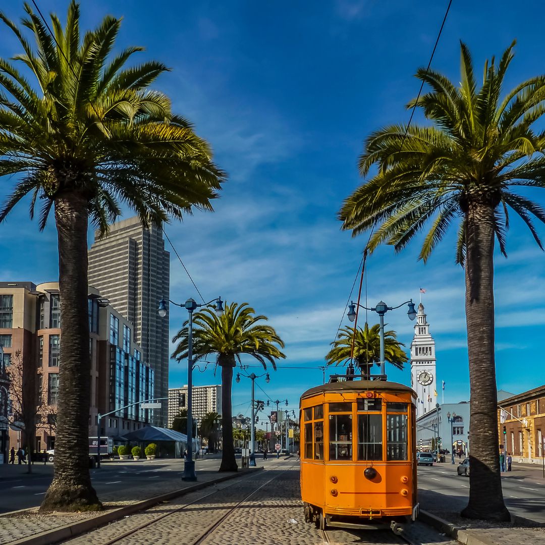 Vintage streetcar on Embarcadero, with palm trees and the Ferry Building