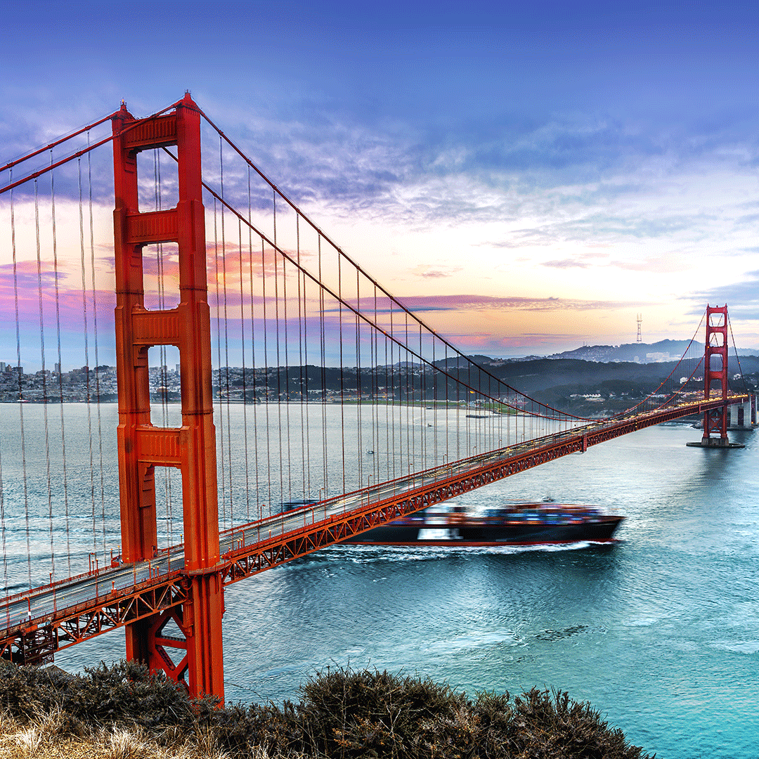 Golden Gate Bridge with a dramatic sky and a ship passing below