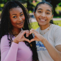two women on campus make a heart with their hands for SFSU Gator Giving Day