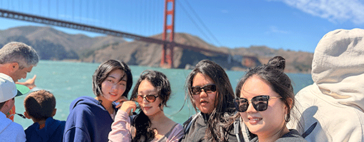 International students on a bay cruise with the Golden Gate Bridge behind them