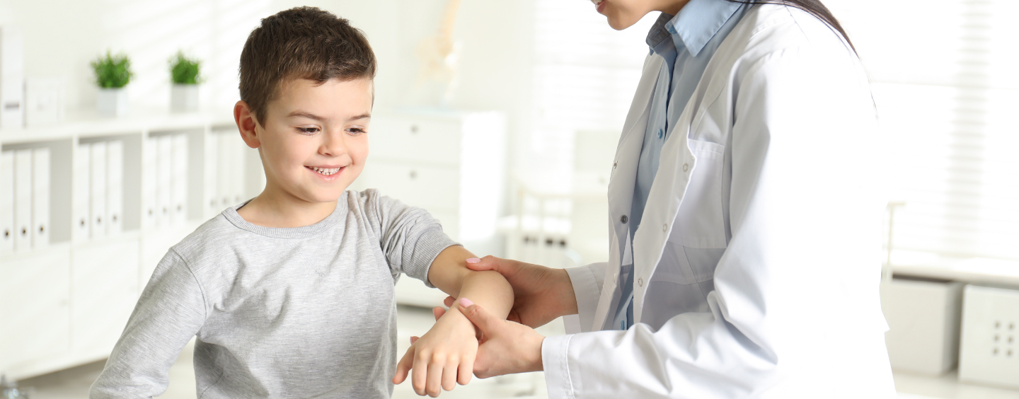 Kid having his arm examined by a school nurse