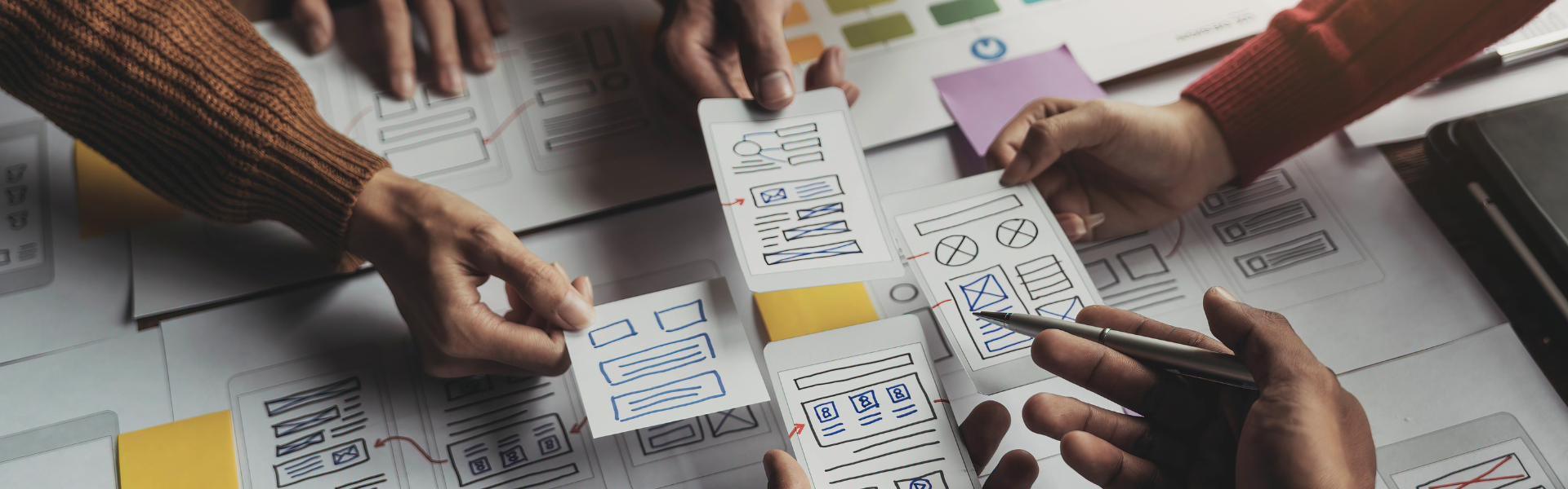 UX Designer hands holding paper mock-ups