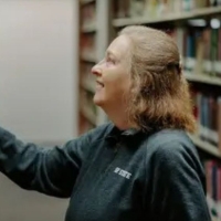 SFSU librarian looking at books in the stacks