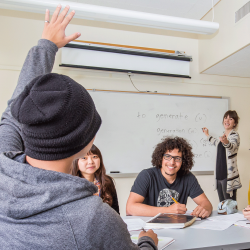 Student raises hand in class and teacher calls on him