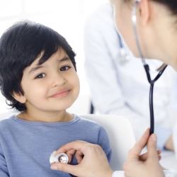 School nurse listens to child's heartbeat