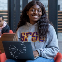 Student in an SFSU sweatshirt taking an online course